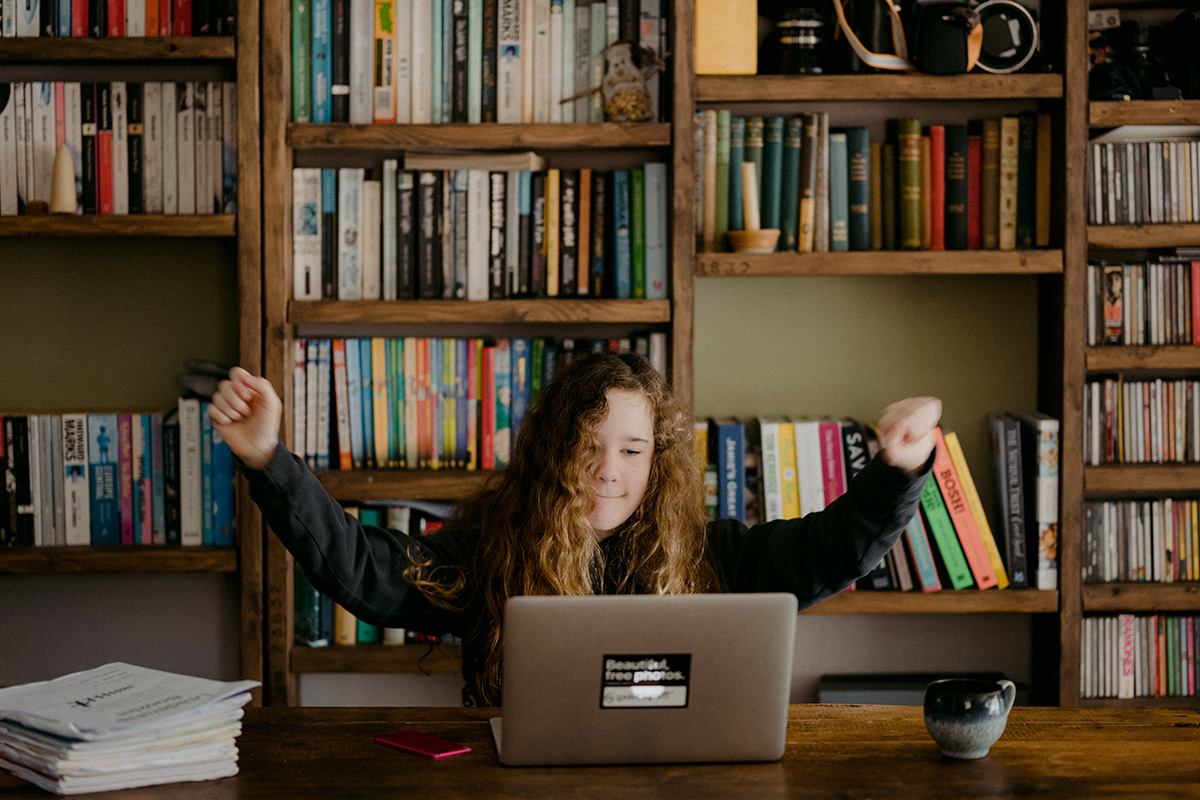 Happy girl behind computer: Annie Spratt
